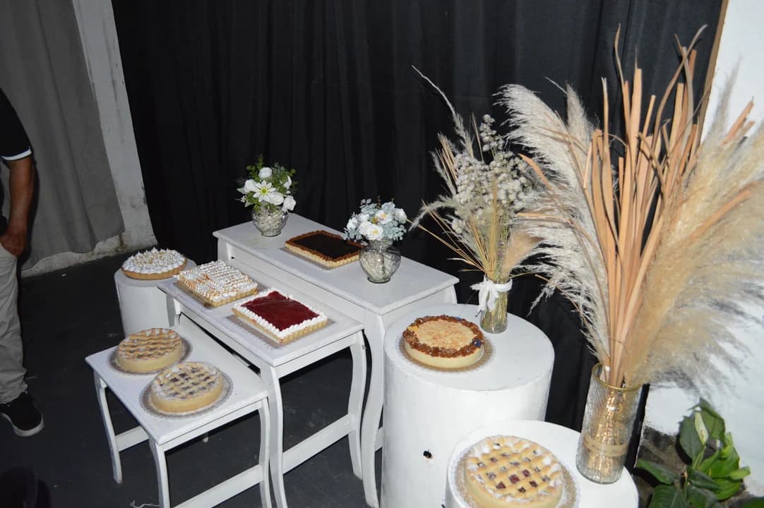 Mesa dulce con tartas variadas y flores de pampa vista lateral