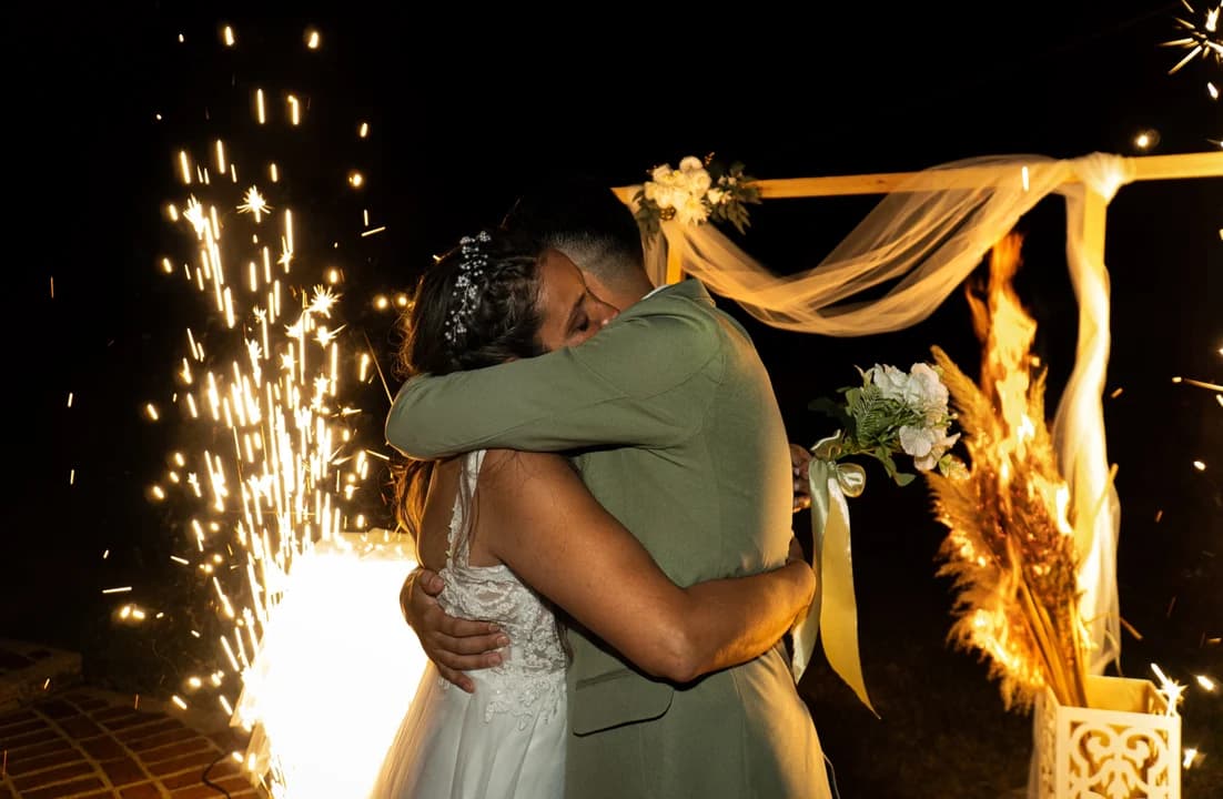 Abrazo de novios con fuegos artificiales