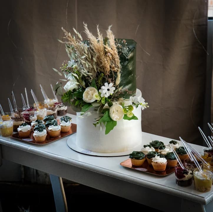 Mesa dulce completa con torta y cupcakes variados