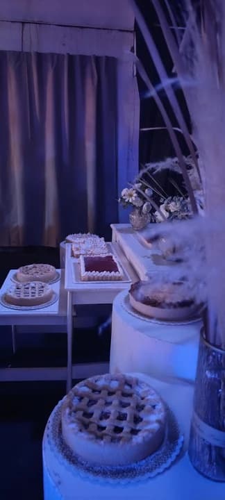 Mesa dulce con tortas y tartas artesanales iluminada con luz azul