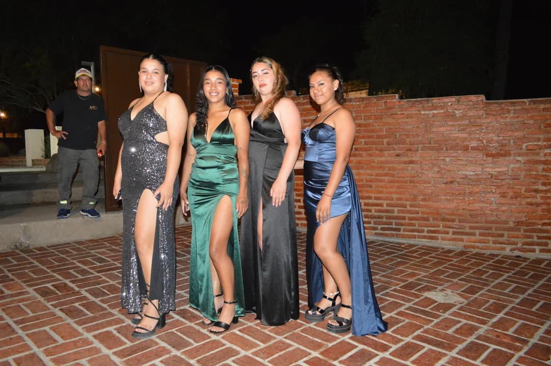 Amigas con vestidos de gala posando en la entrada